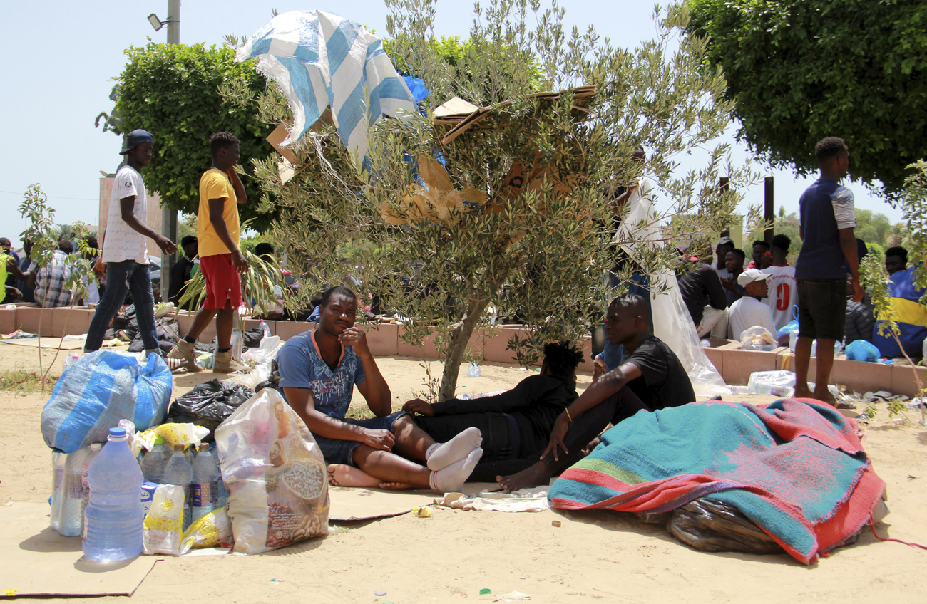 Migrant:innen aus Subsahara sitzen in Tunesien am Boden.