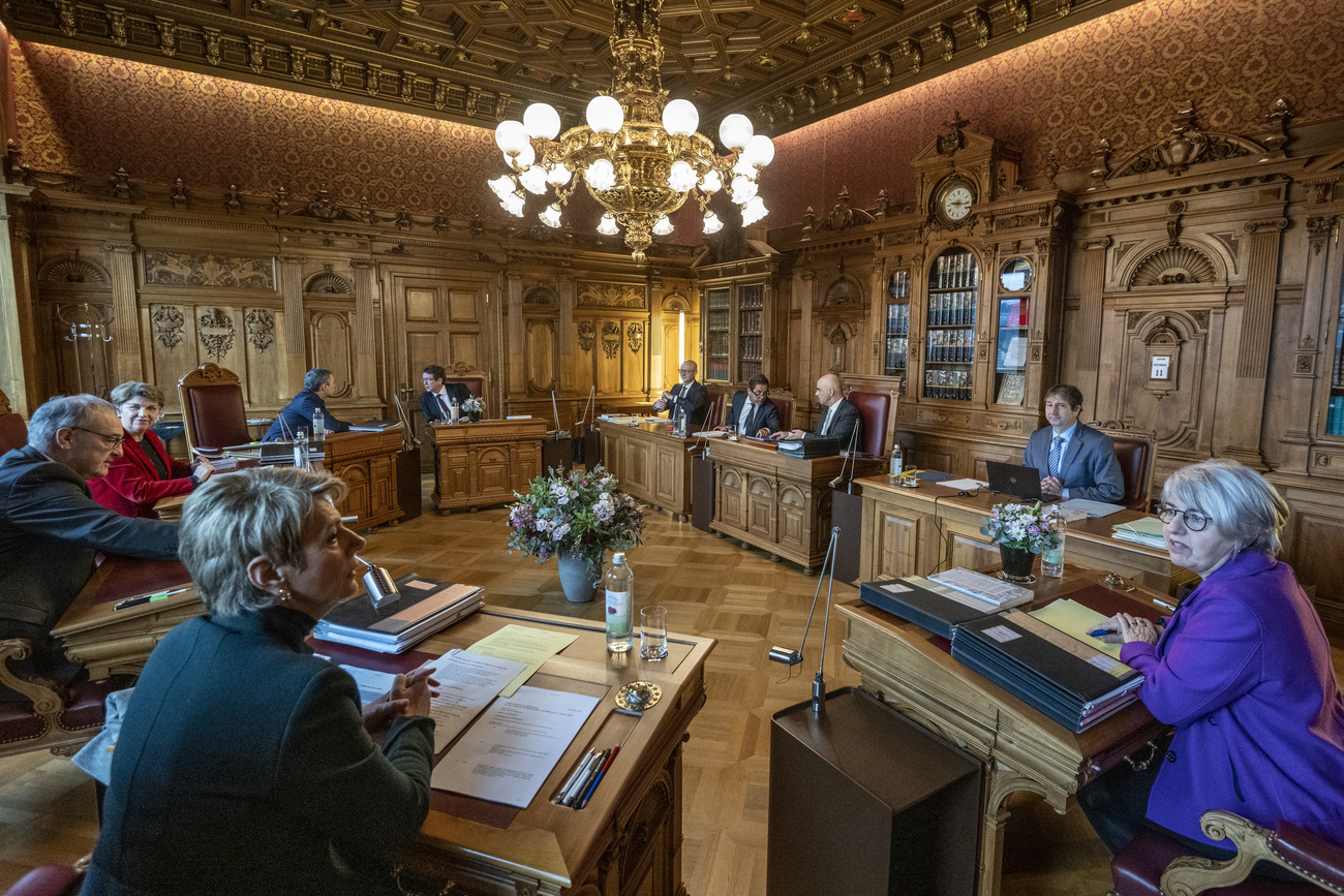 Los siete ministros del Gobierno suizo se reúnen en la sala de gabinete con paneles de madera