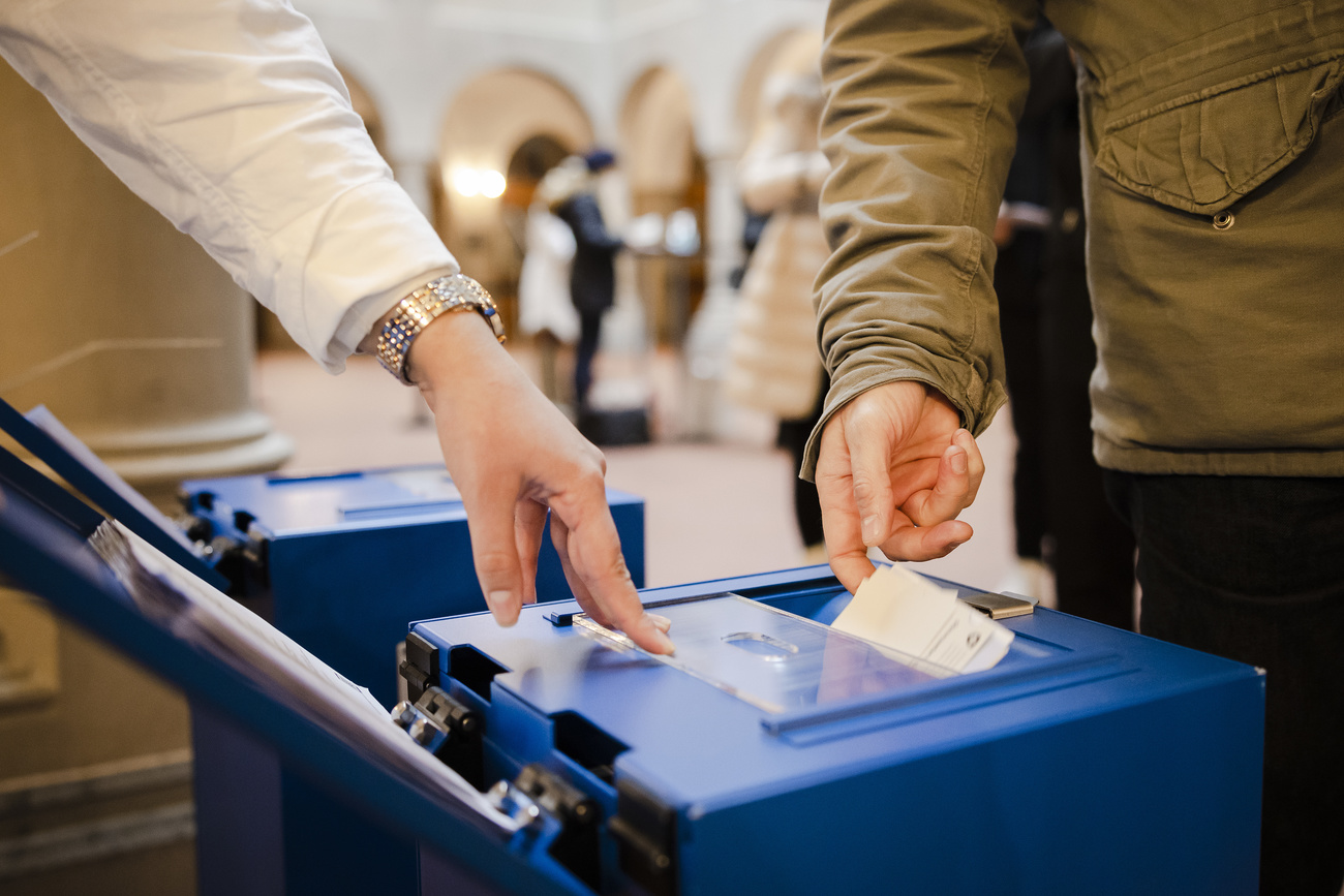 Menschen werfen Stimmzettel in Urne
