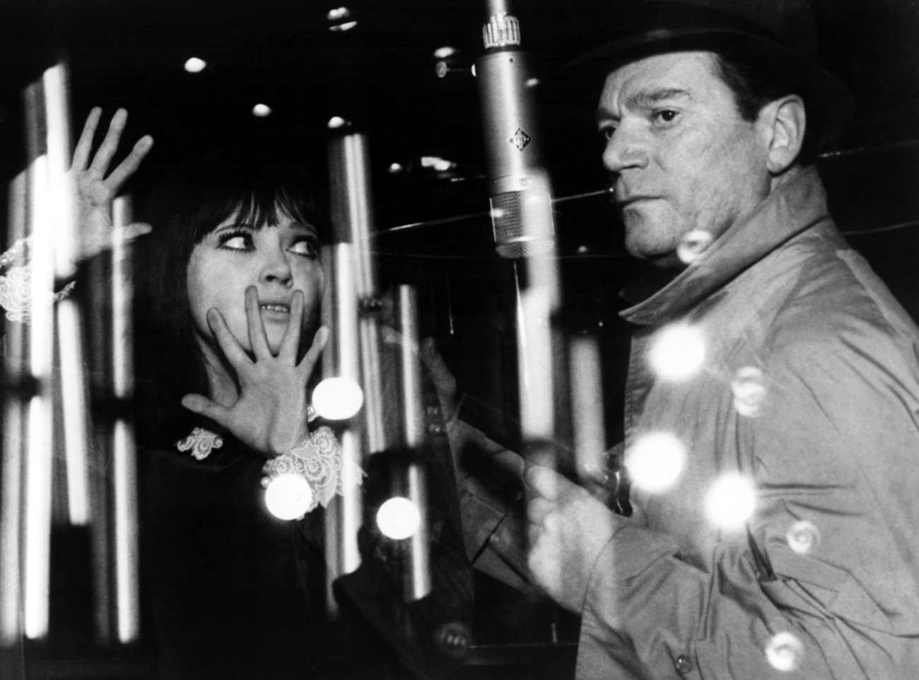 Szene aus Jean-Luc Godard s Alphaville : eine Frau und ein Mann hinter einer Spiegelung