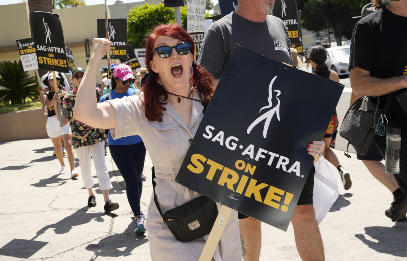 Picture of a woman protesting with sign saying SAG-AFTRA on strike
