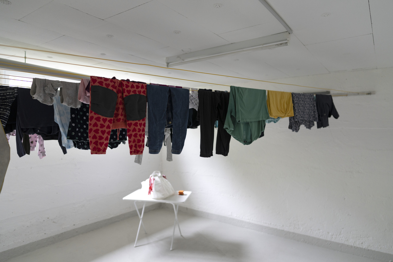 Abiti appesi ad asciugare nella lavanderia condivisa di una casa svizzera.