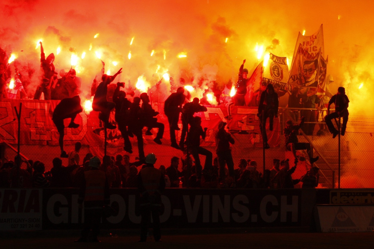 Swiss football fans light flares.