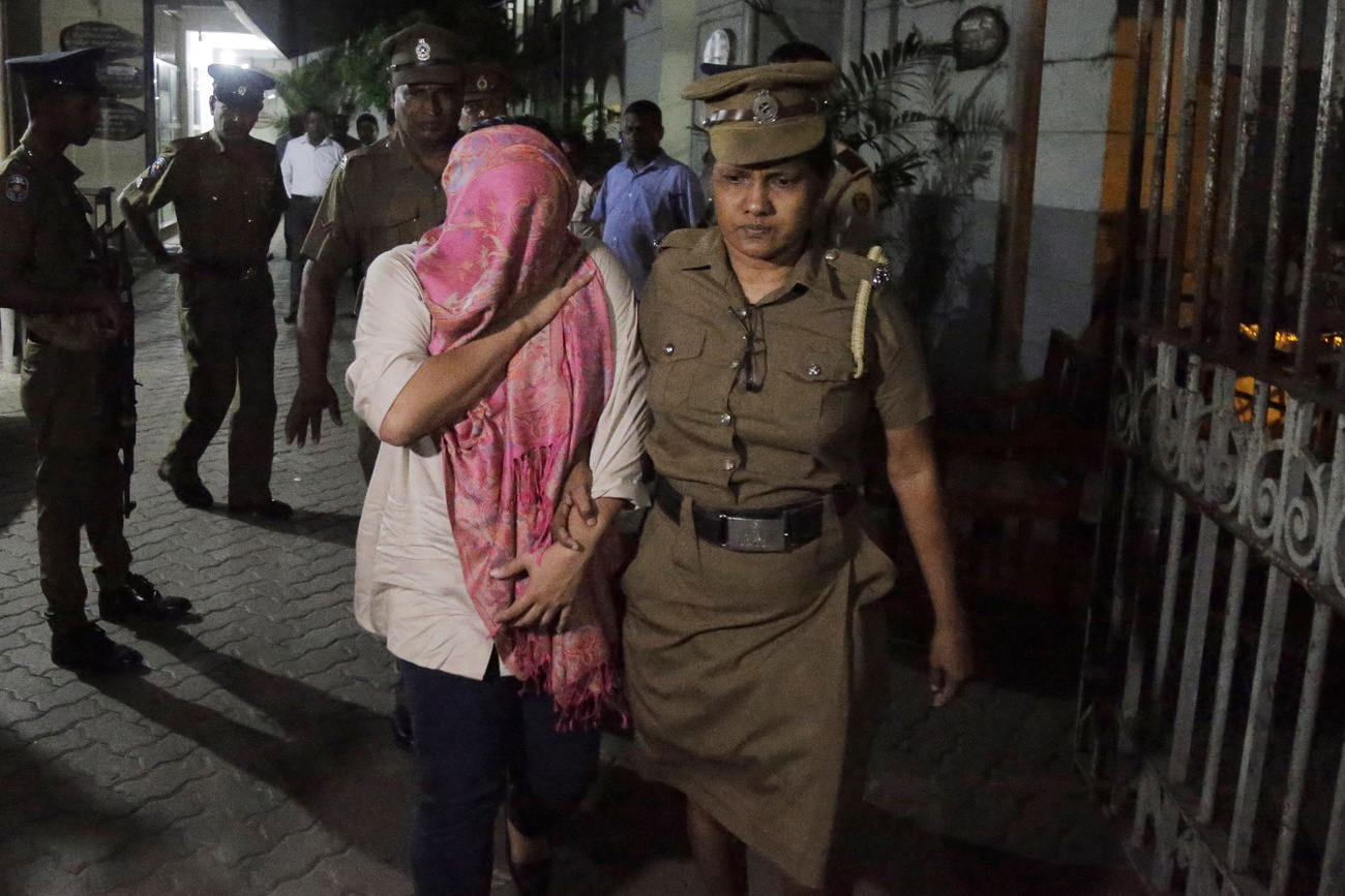 Sri Lankan embassy staffer walks with a police officer