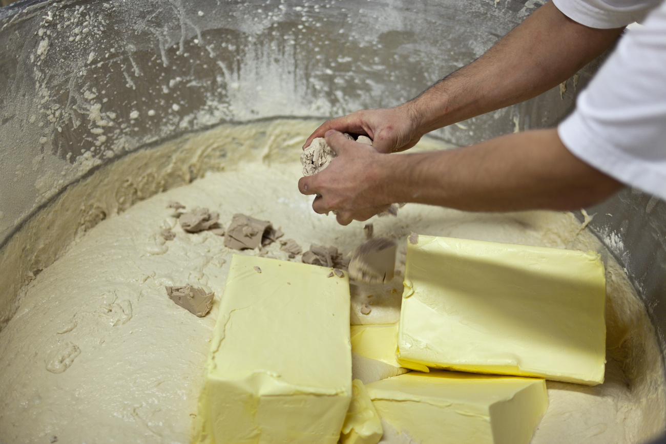 Person mixes butter and sugar in a vat