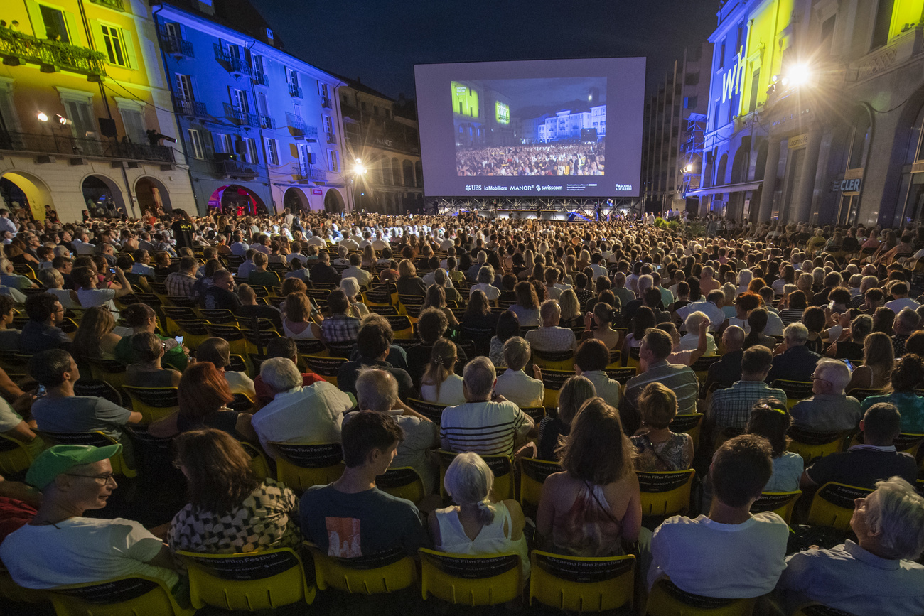 persone in piazza davanti a uno schermo cinematografico