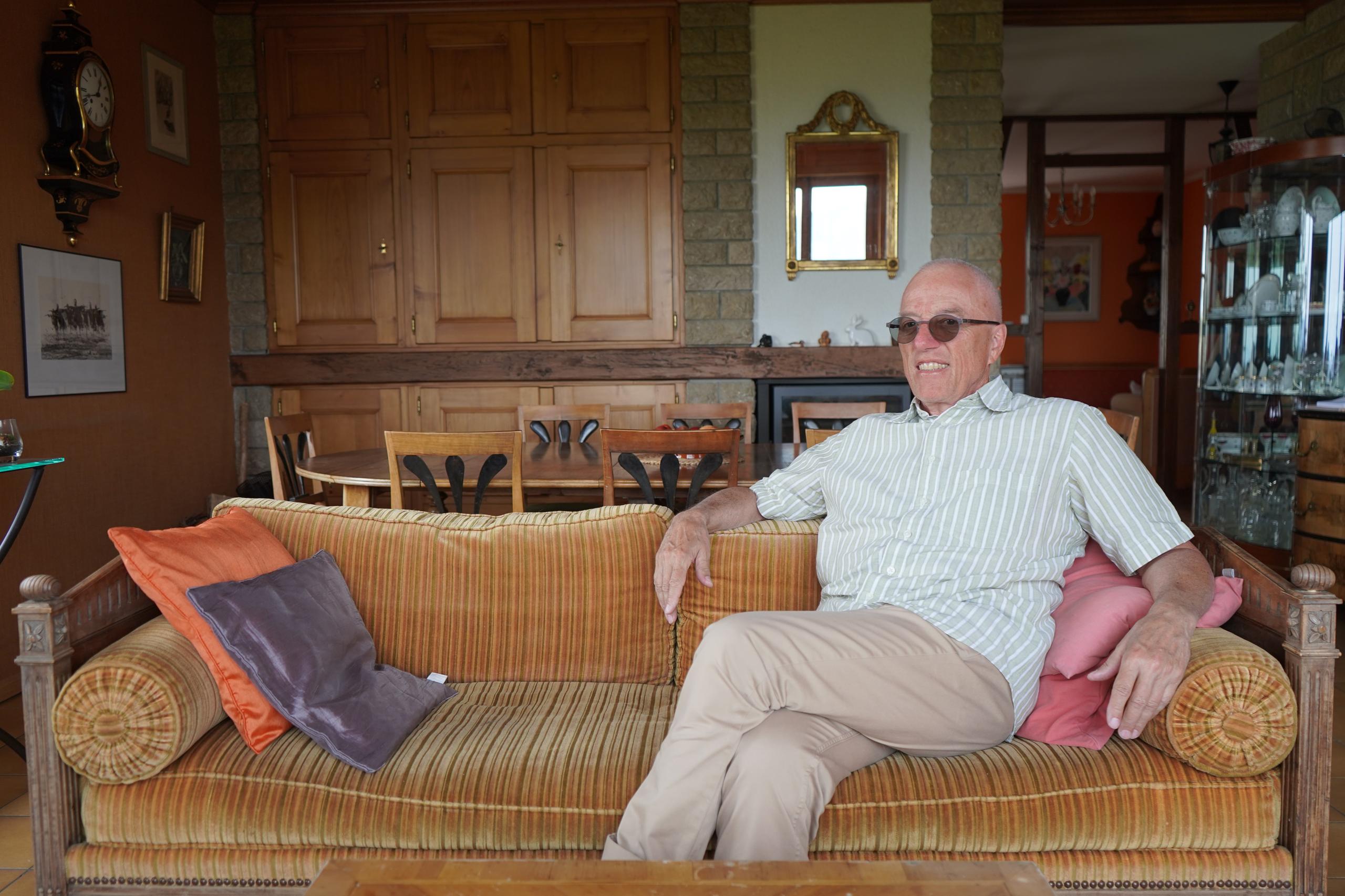 Renaud Tripet auf einer Couch in seinem Wohnzimmer