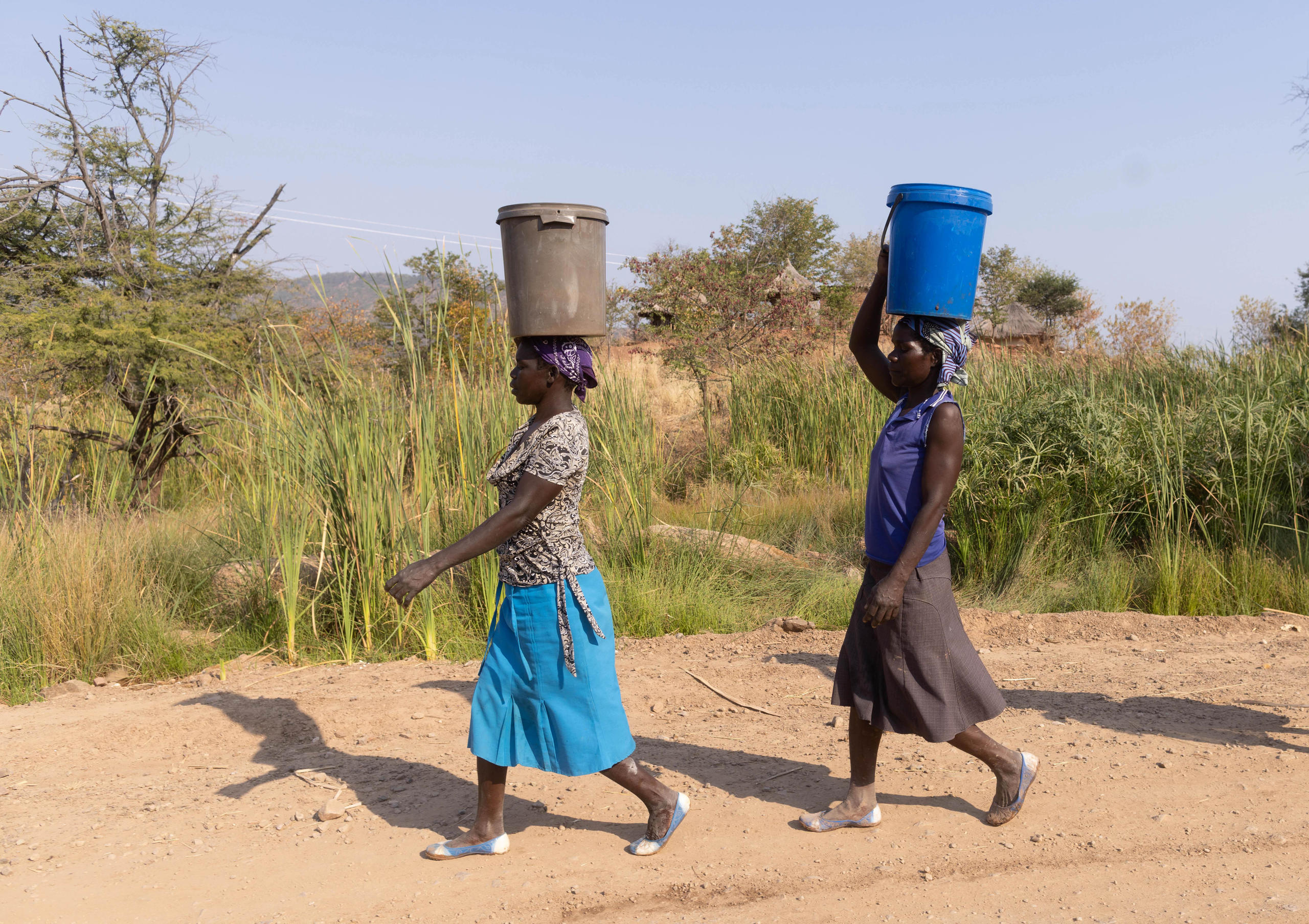 Zwei Frauen tragen Wasser