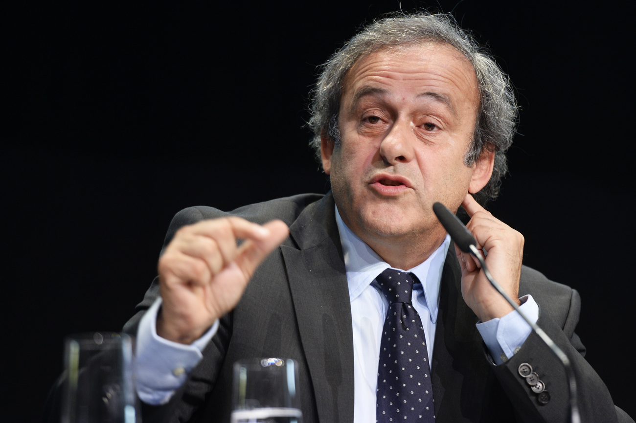 michel platini, nella foto in giacca e cravatta, parla al microfono