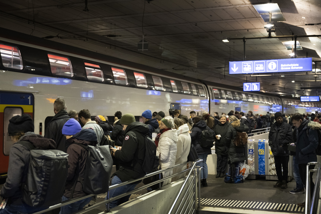 persone in attesa di salire su un treno