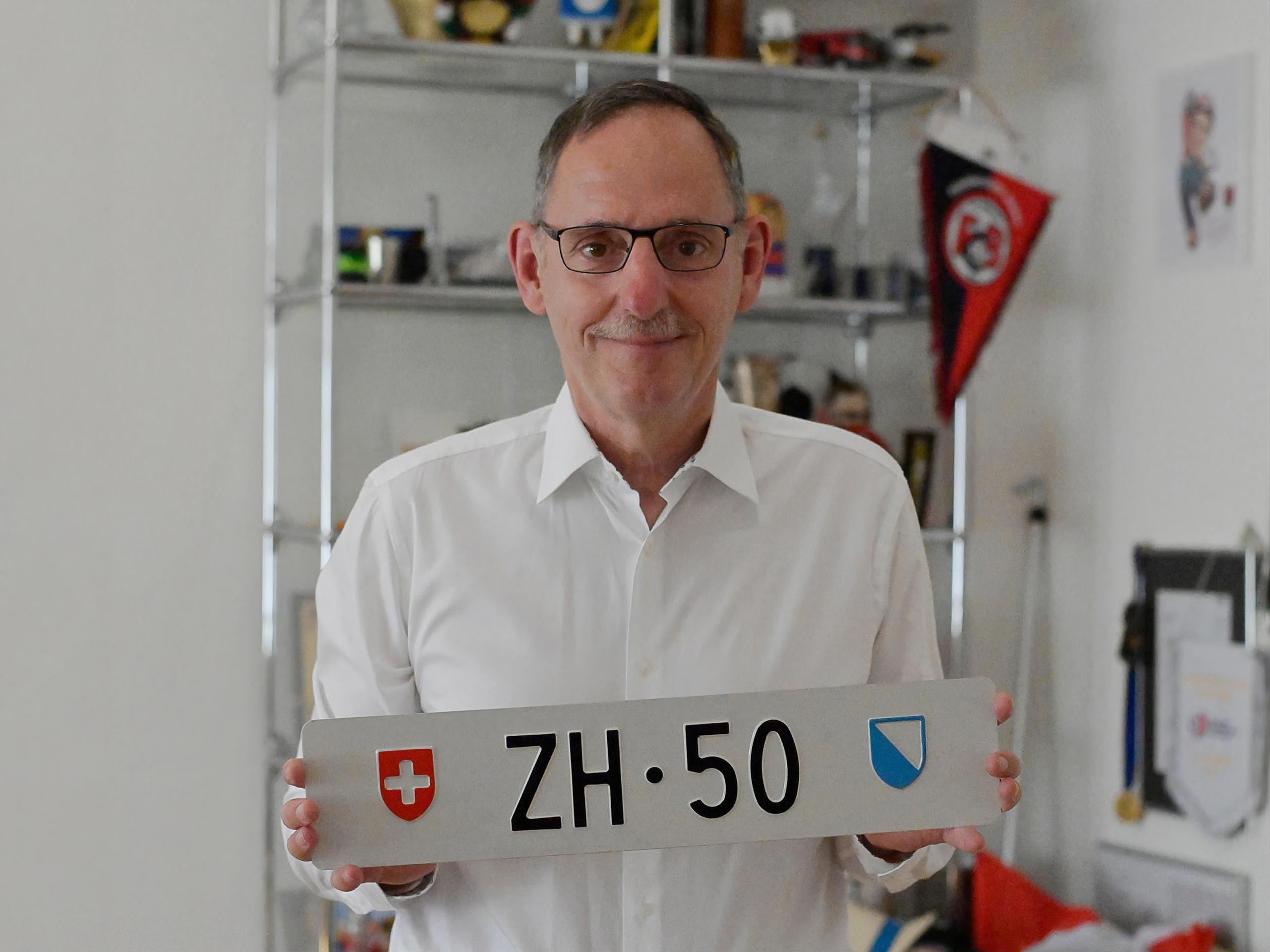 uomo che mostra la targa zh 50