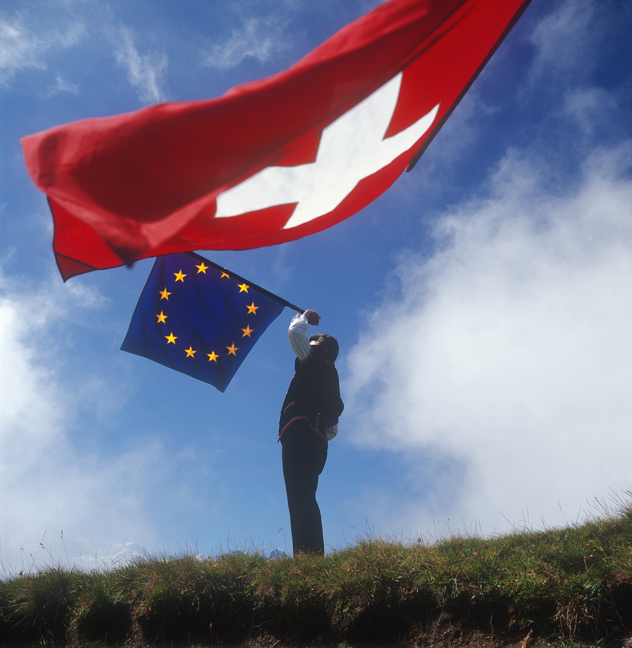 Ein Fahnenschwinger mit EU- und Schweizer Fahne