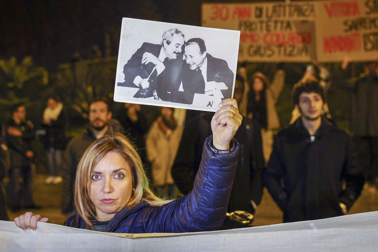 Donna mostra foto dei magistrati anti-mafia Giovanni Falcone e Paolo Borsellino.