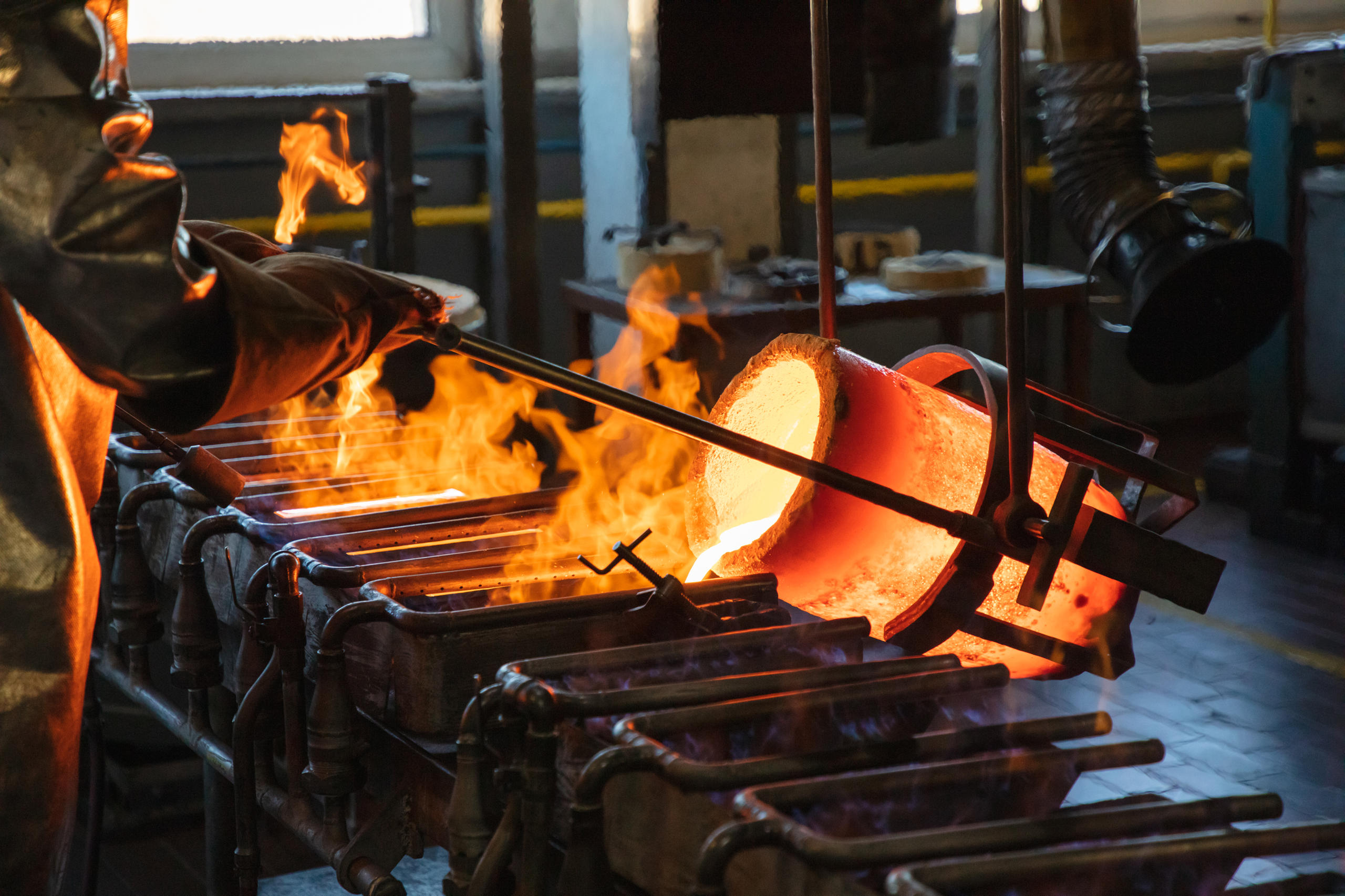 Das geschmolzene Metall wird aus einer glühenden Form in rechteckige Formen gegossen.