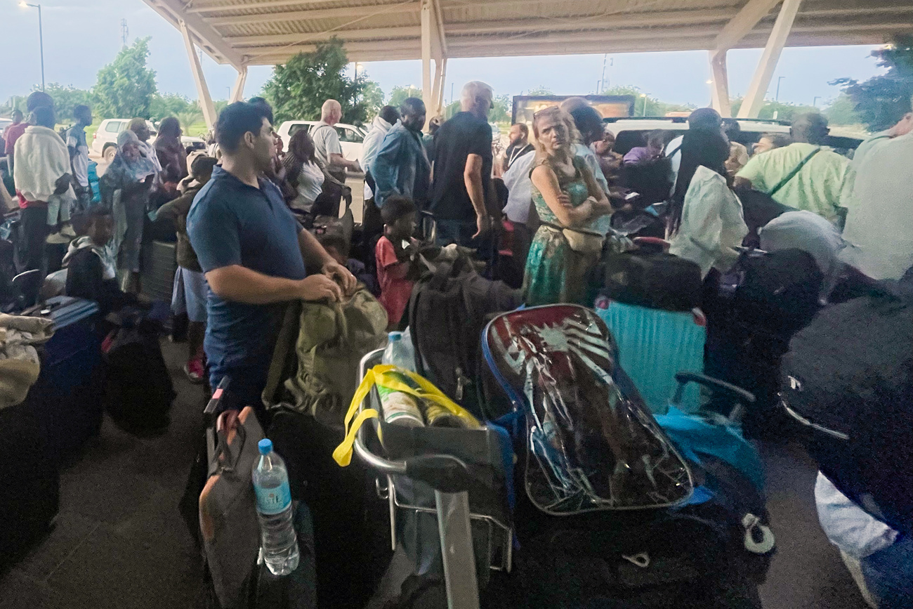 Foule de blancs dans un aéroport africain attendant une évacuation