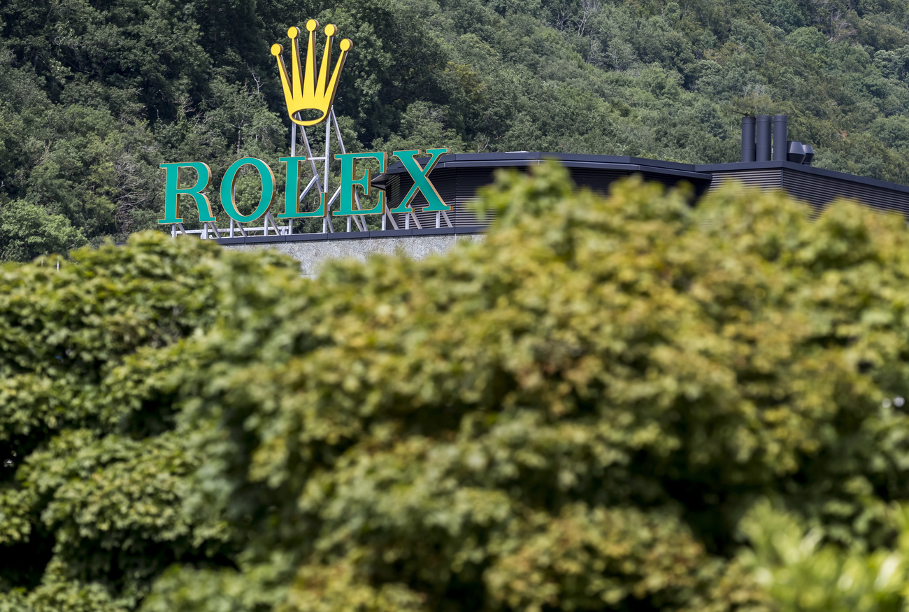 das logo von rolex über bäumen