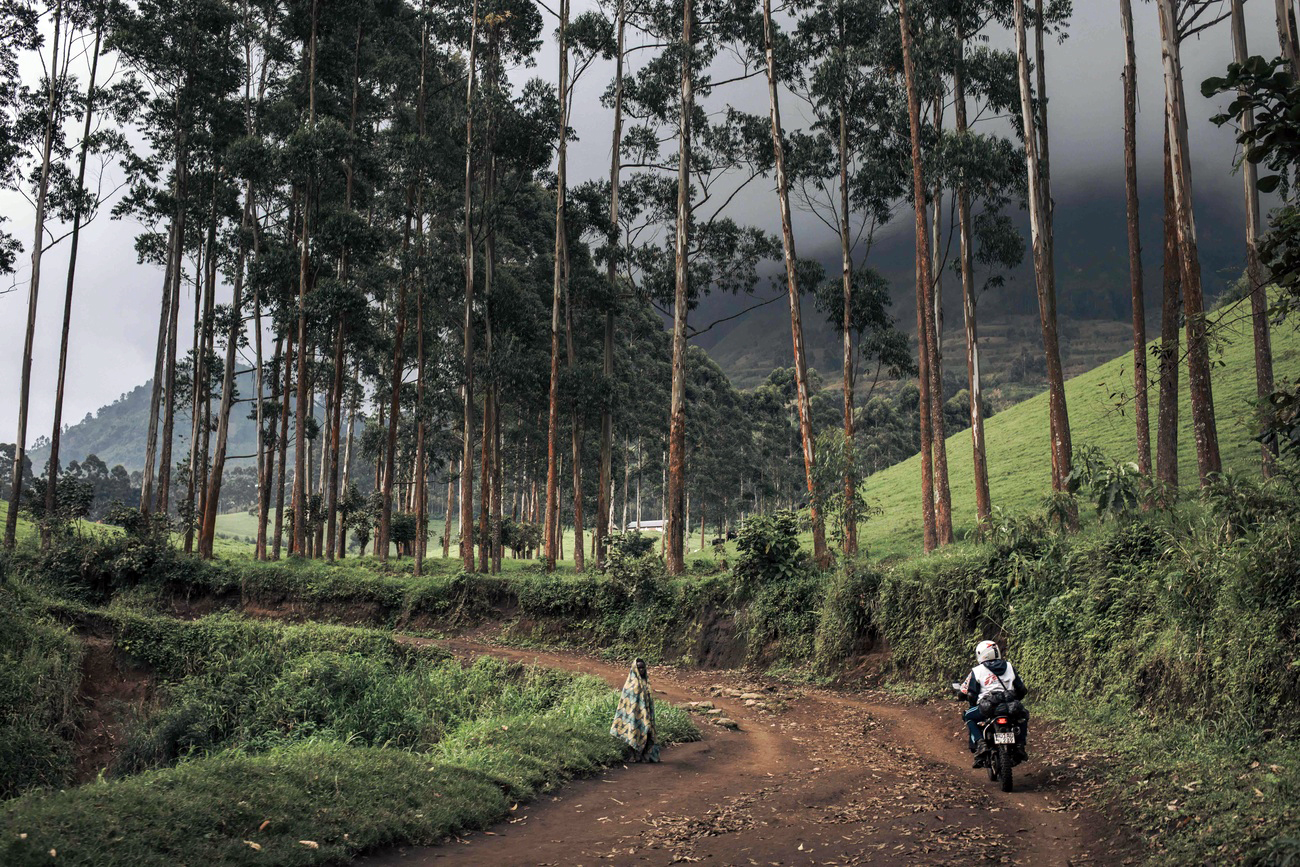 Une jeune fille regarde passer un humanitaire sur une route