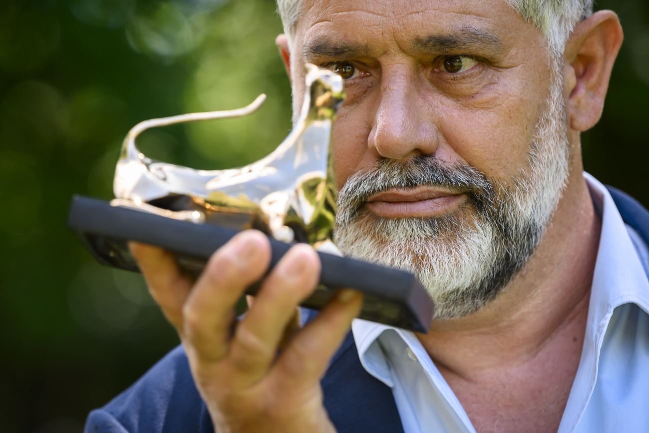 Luc Jacquet gazing at his award in Locarno
