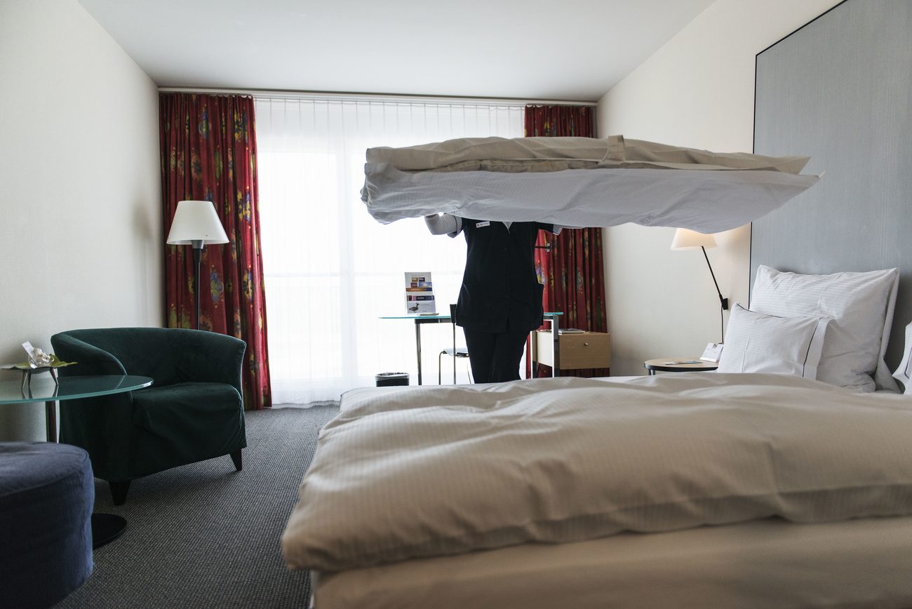Lavoratrice prepara letto in una camera d albergo.