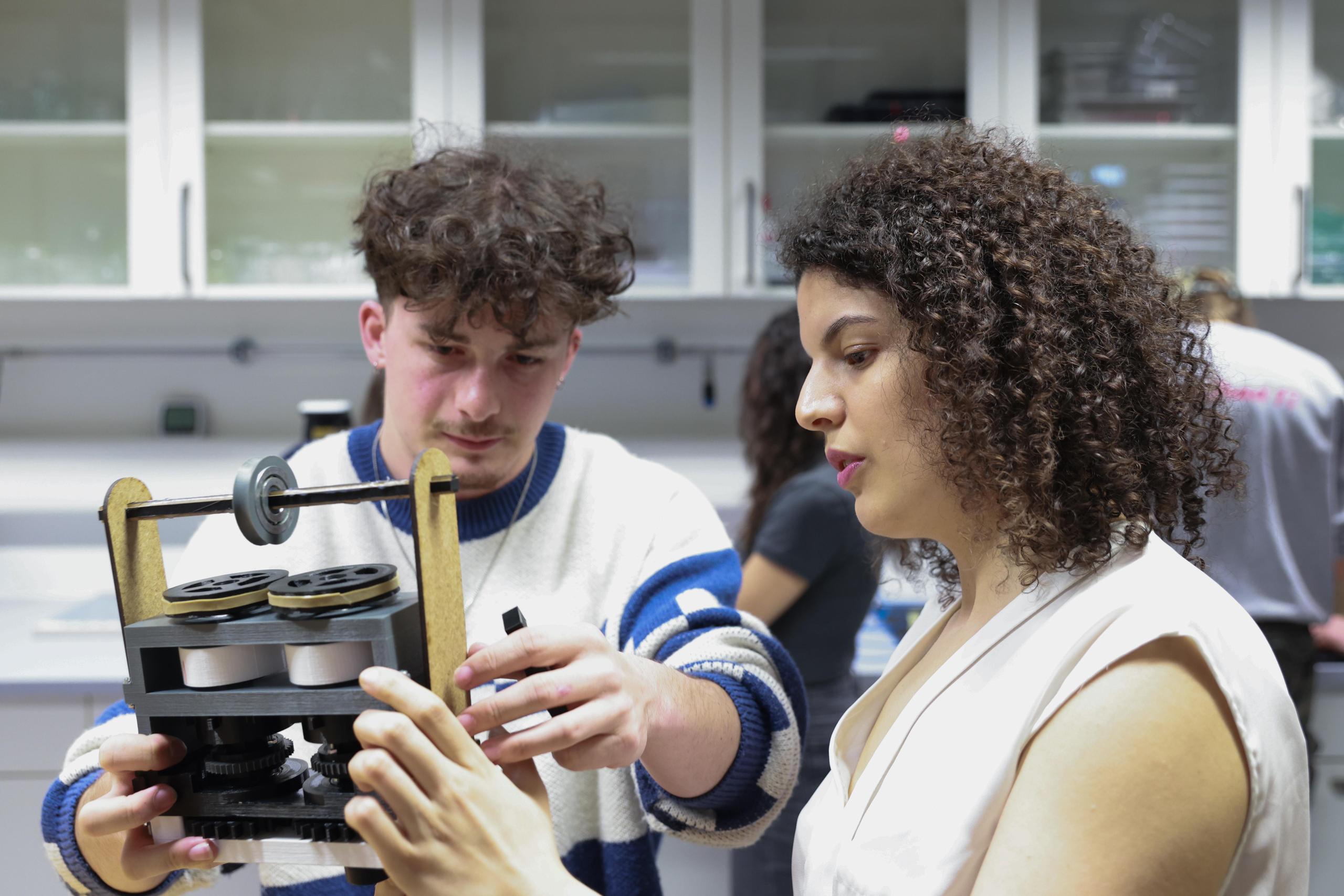 Due studenti del Politecnico federale di Losanna con una macchina di Leonardo da Vinci.