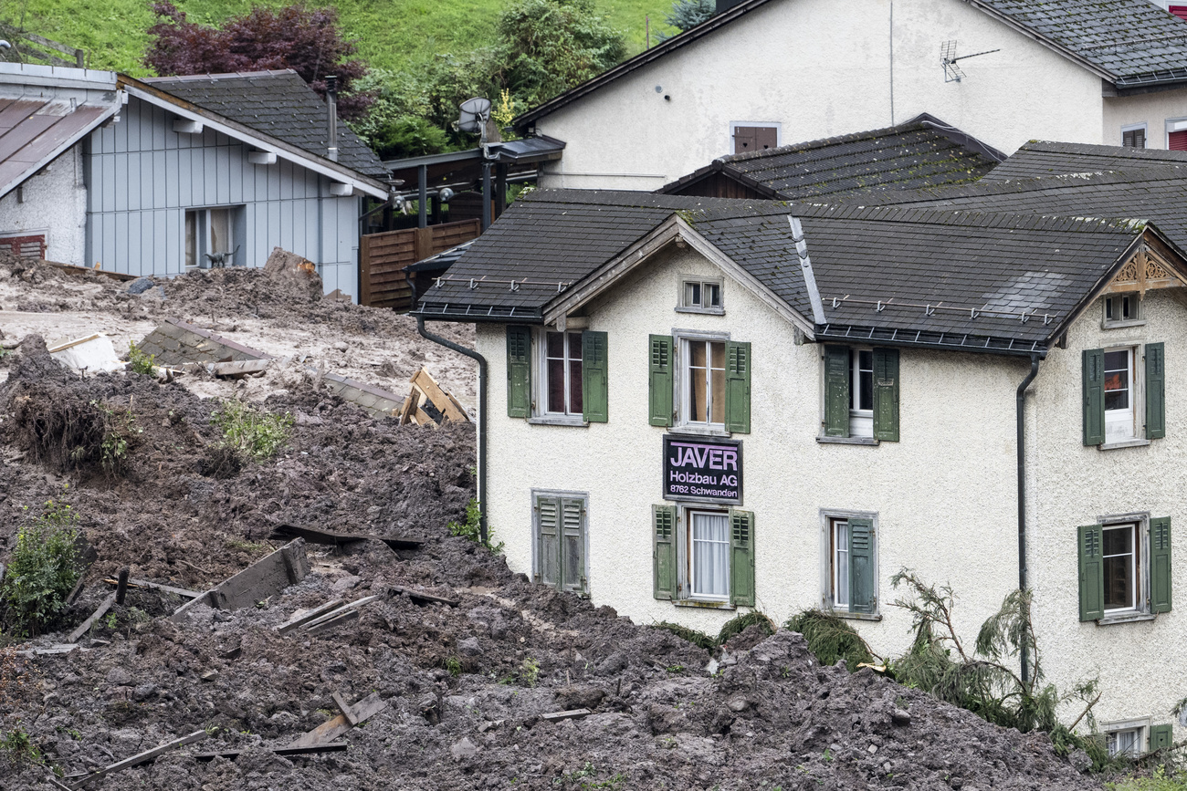 Halb von Erdmassen verschüttetes Haus