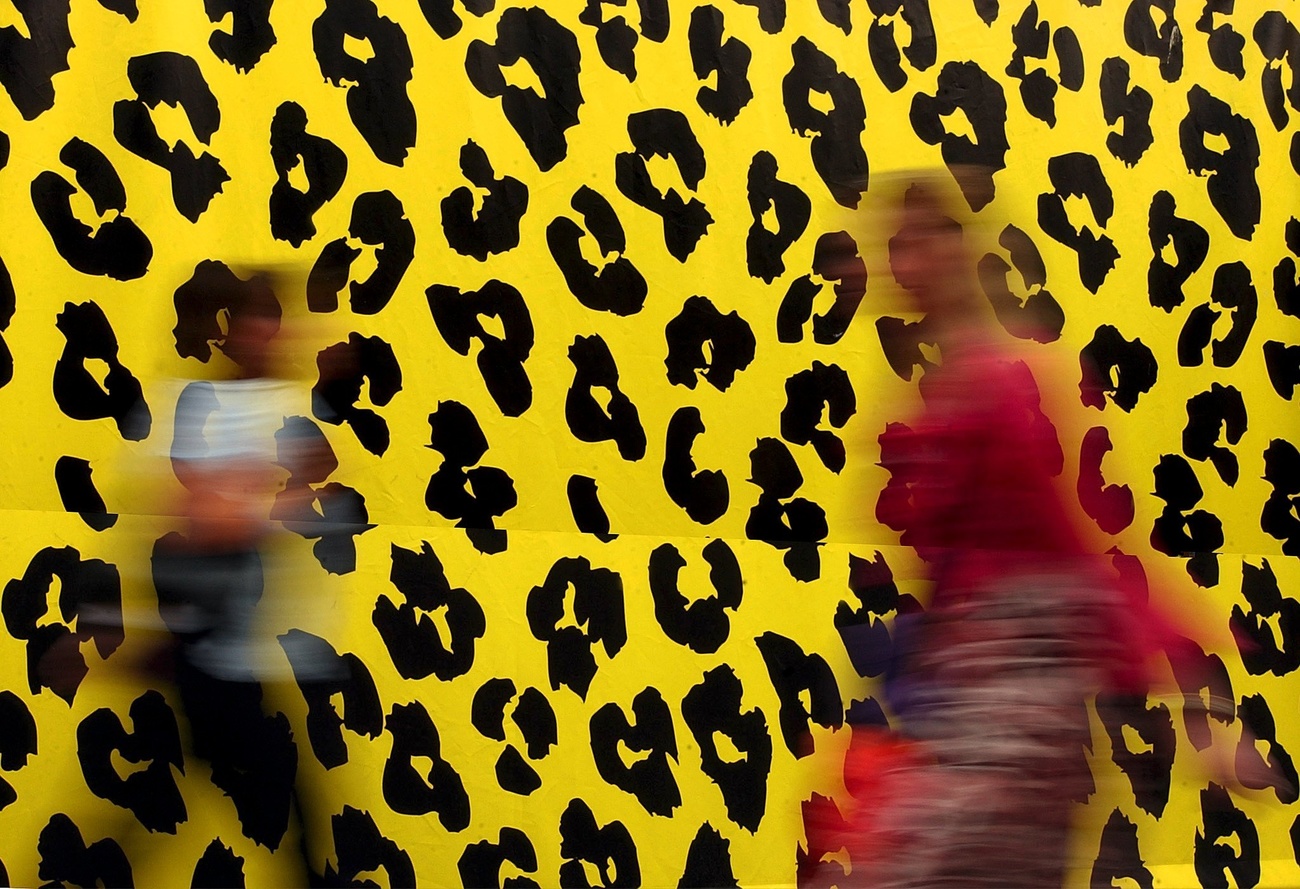 Verschwommene Menschen vor einer Wand im Leopardenmuster