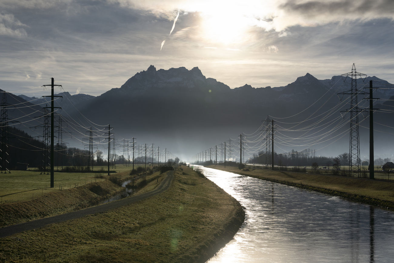 a curving river with sun and mountains in background