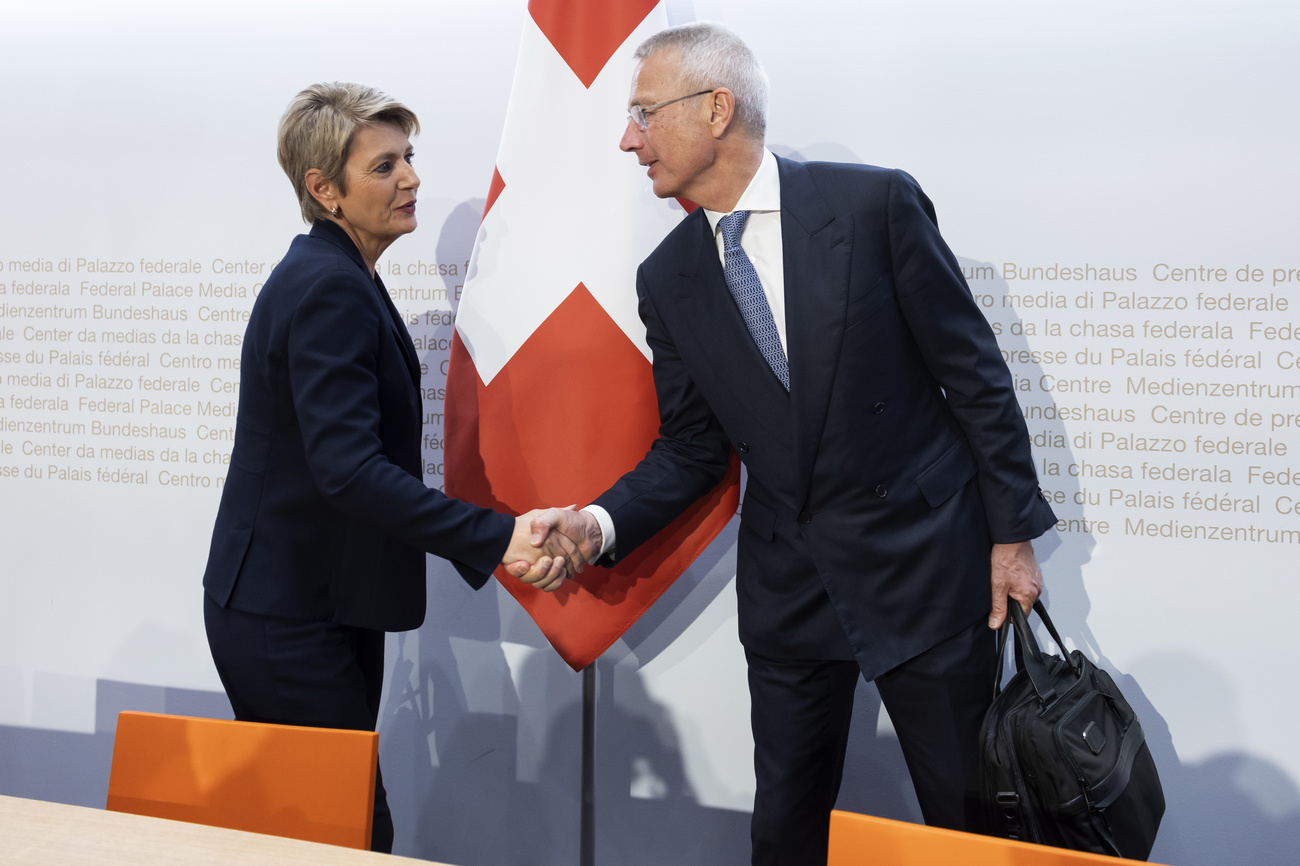 Swiss Finance Minister Karin Keller-Sutter and CS chair Axel Lehmann shake hands