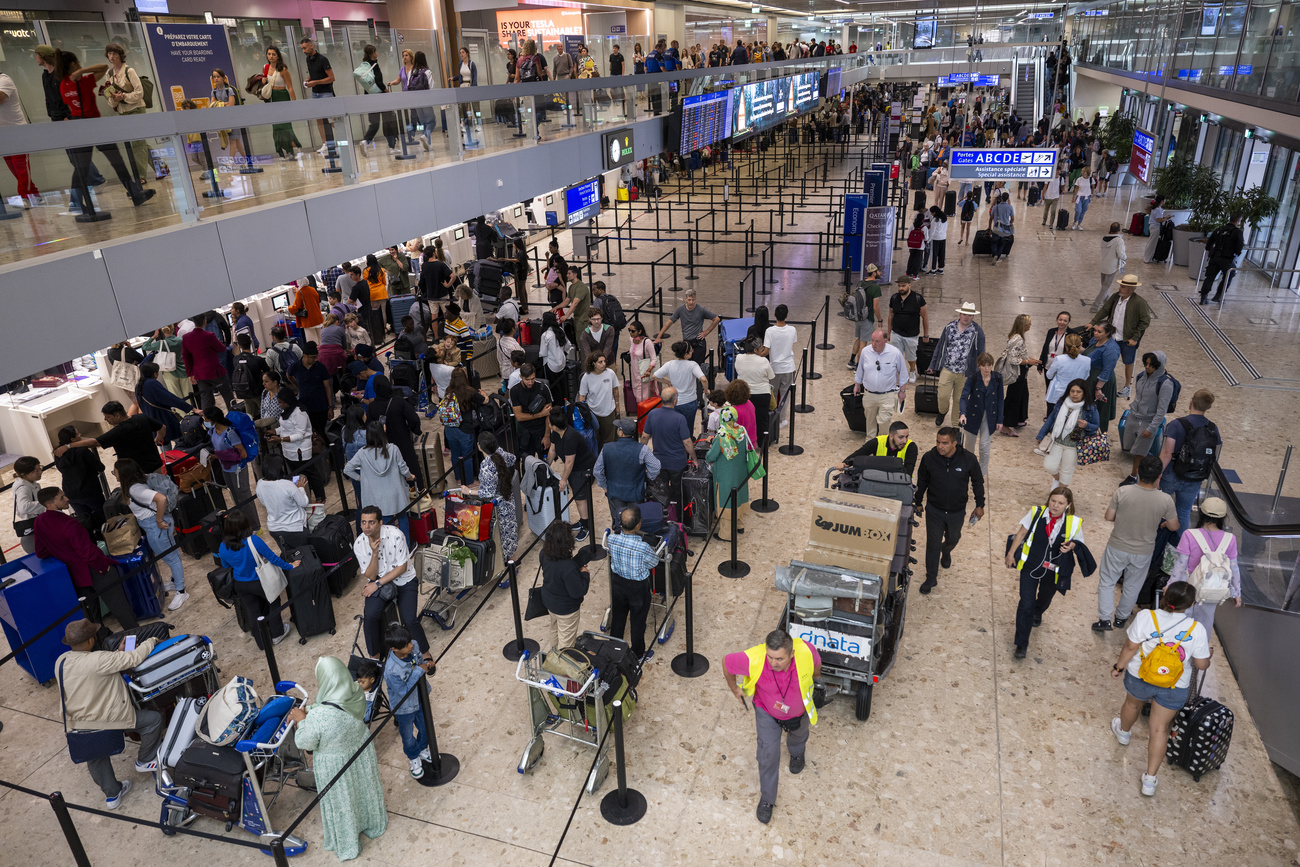 Viele Menschen stehen an den Schaltern fürs Flughafen-Boarding an.
