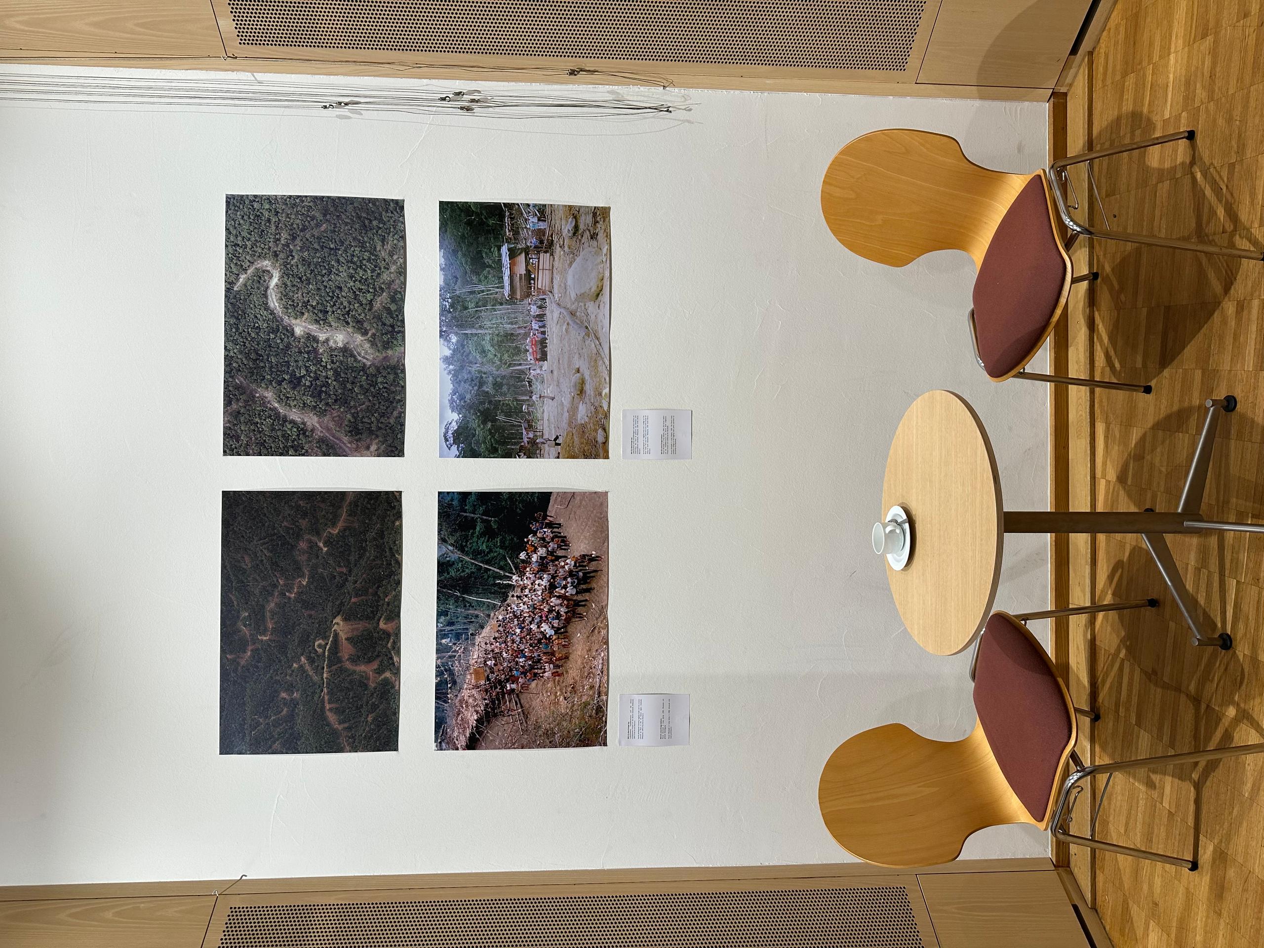 Bilder an einer Wand über einem Tisch mit zwei Stühlen