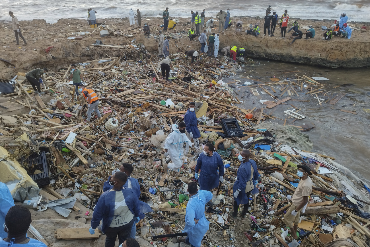 Si scava fra i detriti sulla costa di Derna, in Libia.
