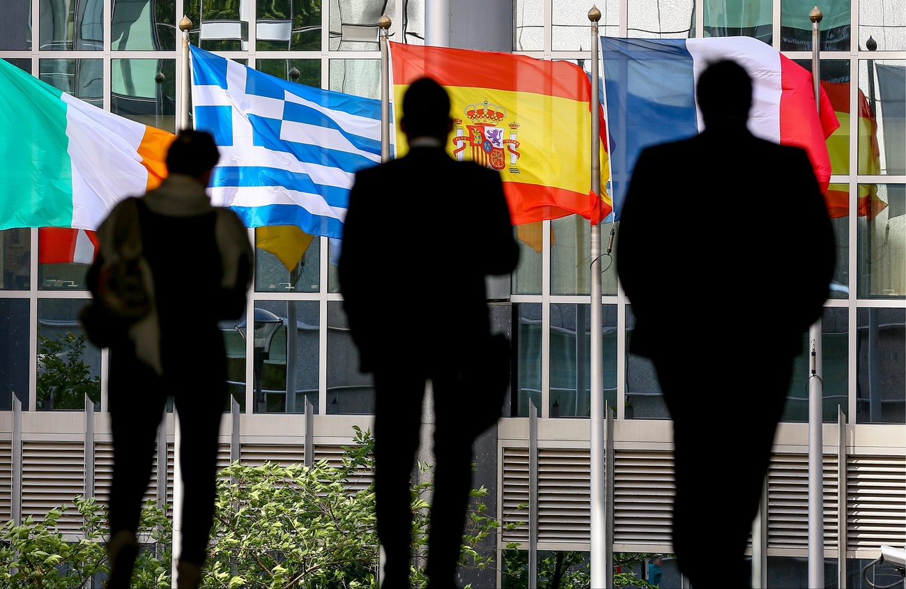 Trois hommes devant des drapeaux de pays européens