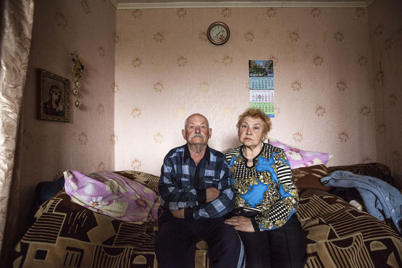 Anziana coppia ucraina in attesa seduta su un letto