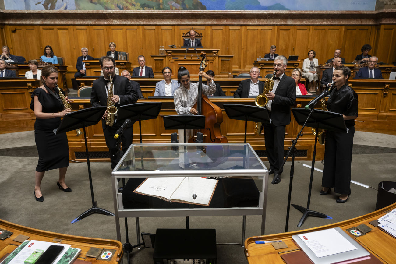 Un groupe joue de la musique devant la Constitution exposée au Parlement