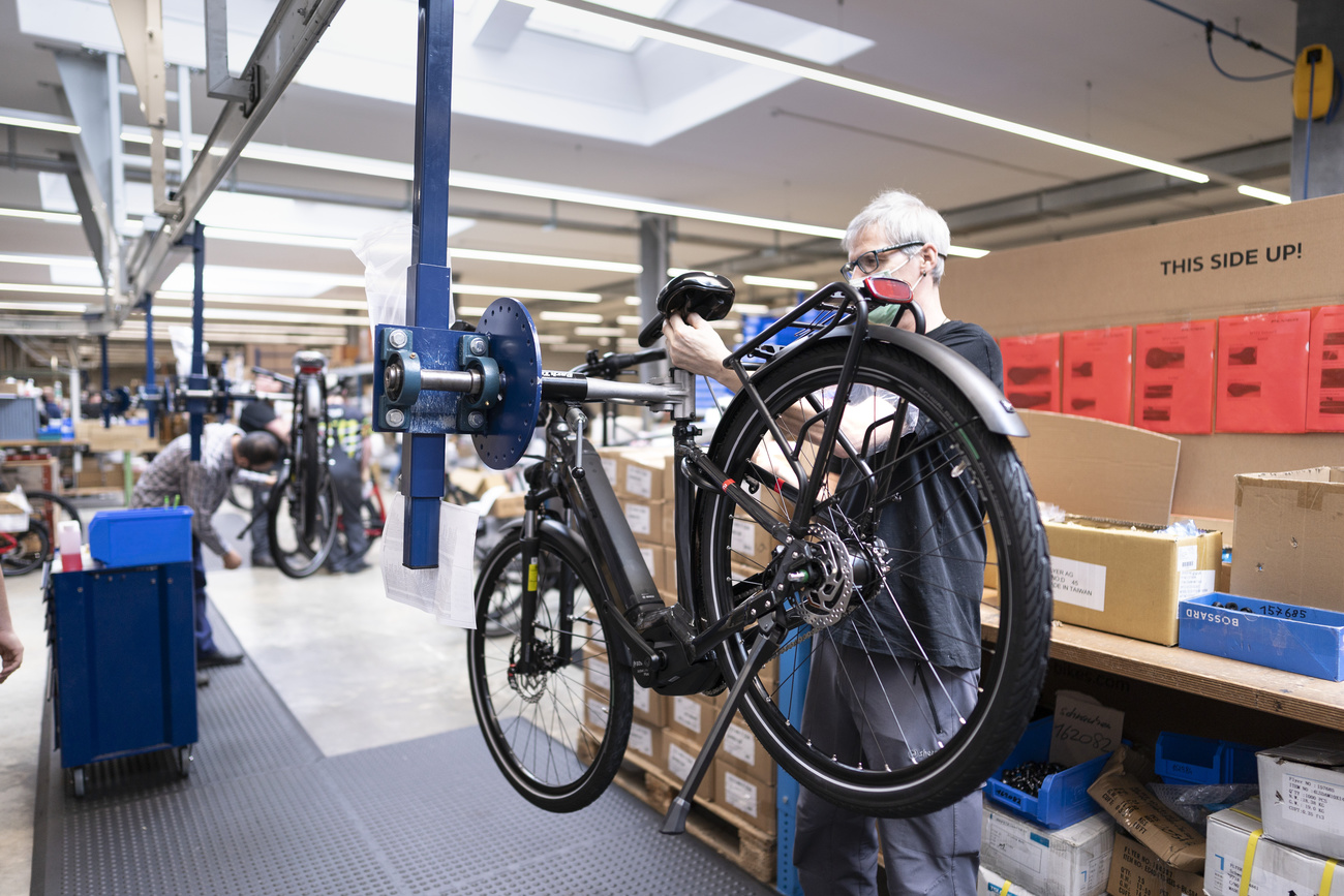 Mann arbeitet an einem E-Bike in einer Halle