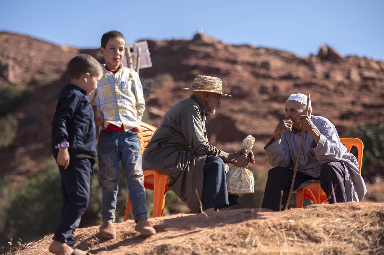 Moroccans sit on a mountain ledge