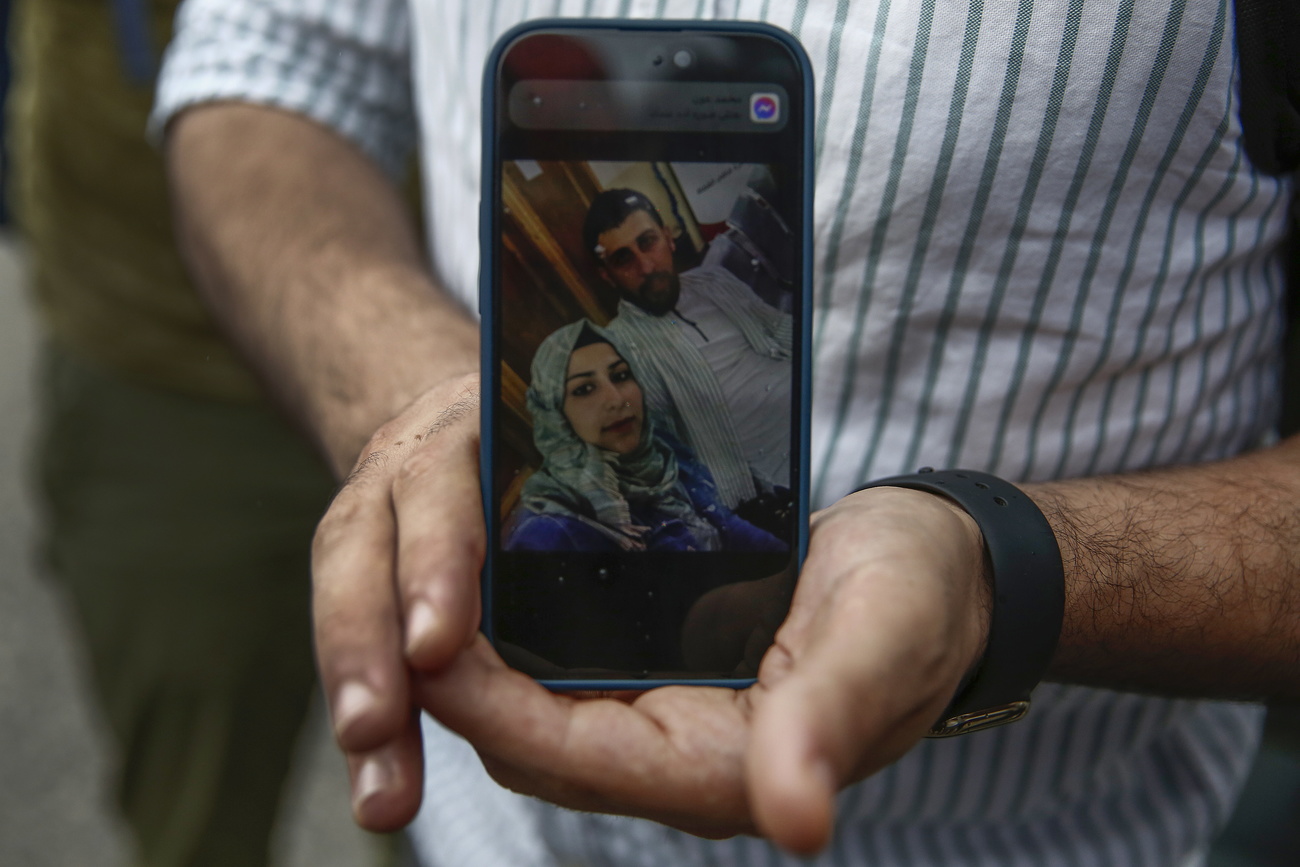 Syrian refugee with missing wife picture on phone