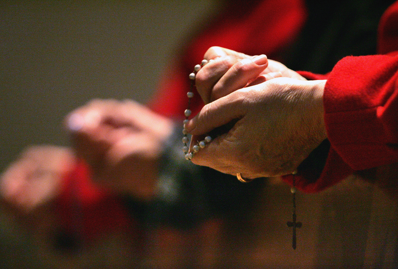 Man holding chain with cross.