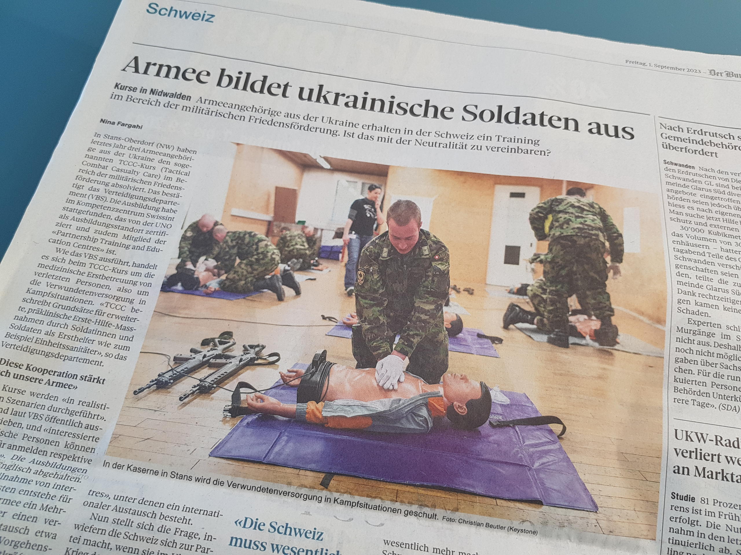 Zeitungsausschnitt mit Bild von ukrainischen Soldaten bei Ersthilfe-Ausbildung