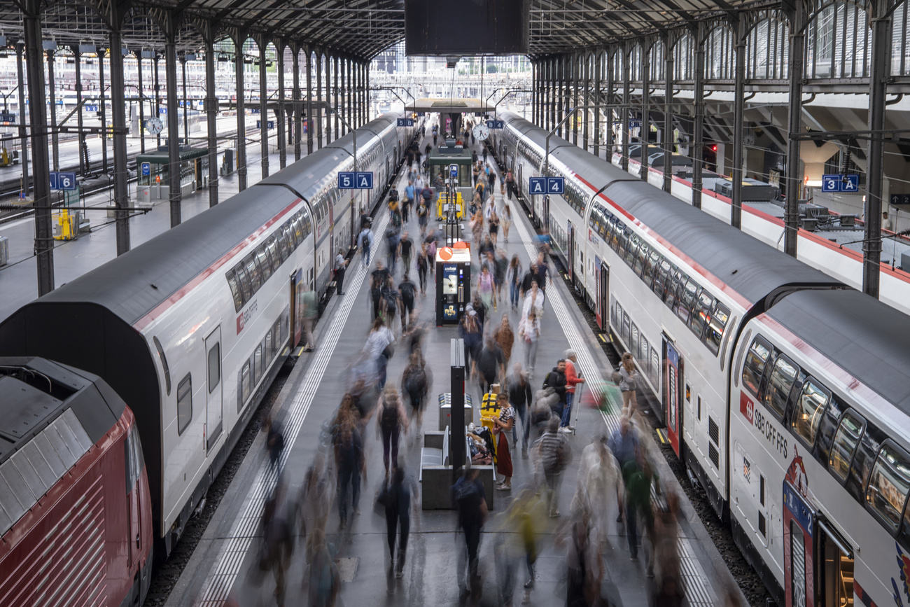 Langzeitbelichtung in einem Bahnhof, viele Menschen als verschwommene Umrisse