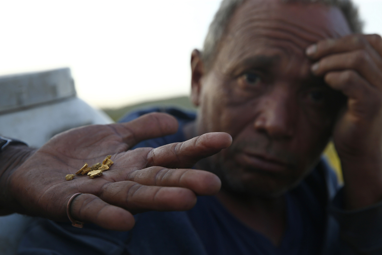 Homem com uma pepita de ouro na mão