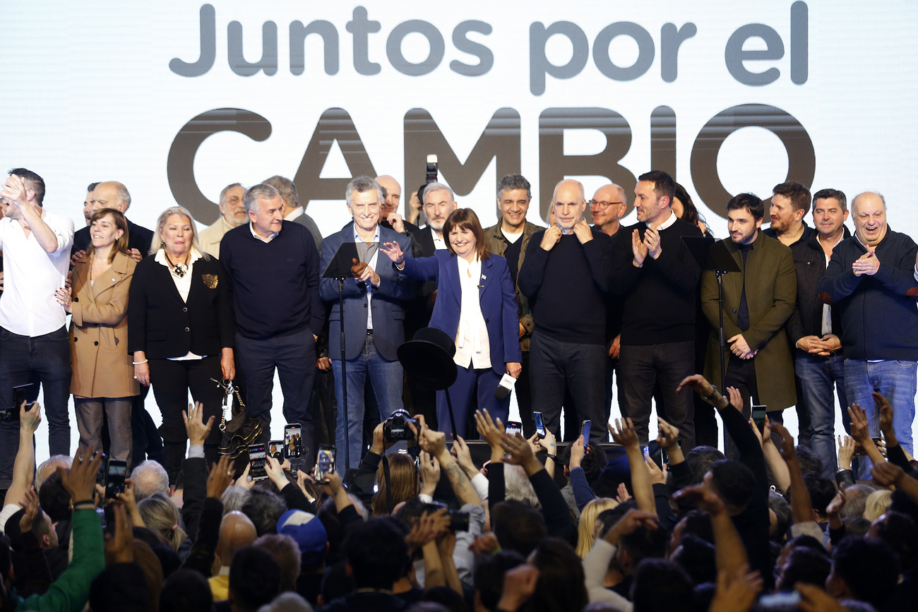 Foto de los miembros del partido con el lema en grande detrás de ellos, juntos por el cambio