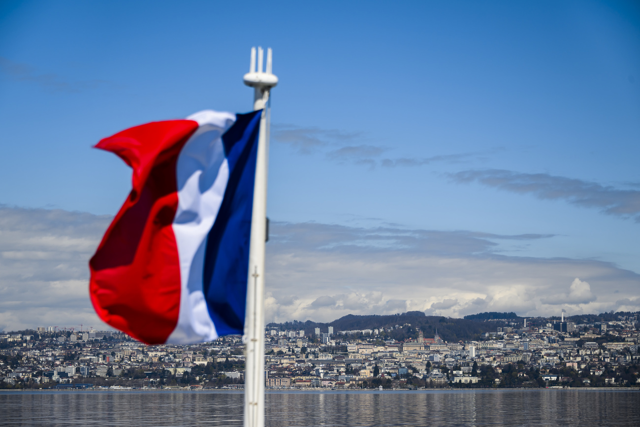 Una bandiera francese e sullo sfondo la città di Ginevra.