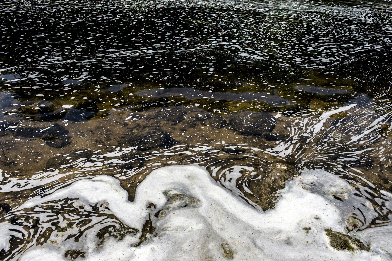 PFAS foam gathers at the the Van Etten Creek dam in Oscoda Township, Mich., near Wurtsmith Air Force Base on June 7, 2018