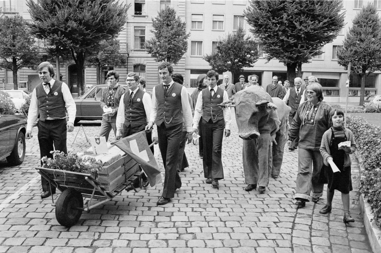 photo en noir et blanc de personnes avec une brouette emplie de papier