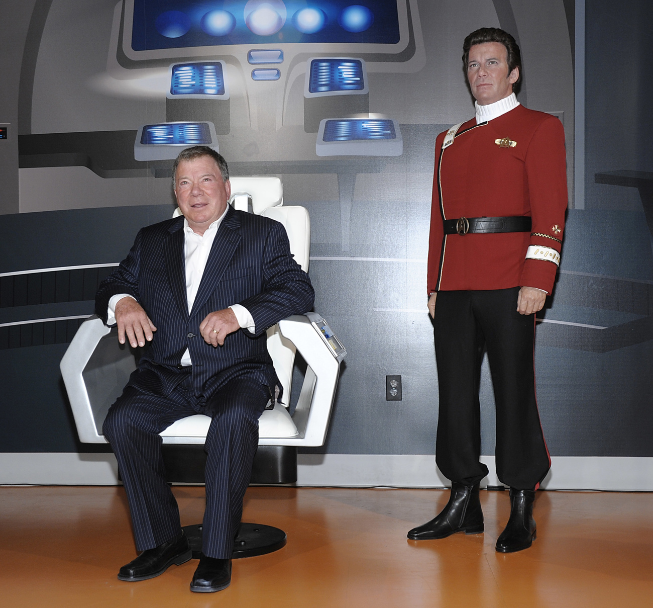 William Shatner sitzt neben einer Wachsfigur von sich selbst als Captain Kirk