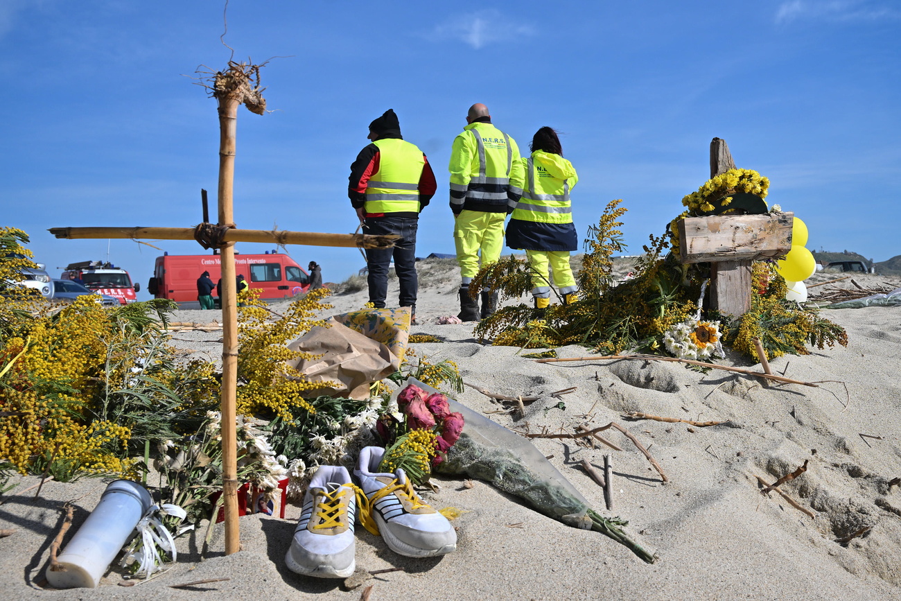 Fiori e una croce sulla spiaggia di Steccato di Cutro.