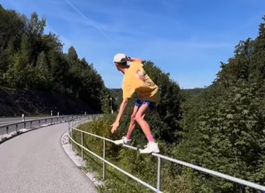 Junger Mann, der ein Strassengeländer hinunter gleitet