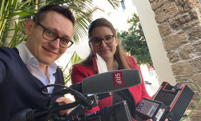 Mann und Frau mit einer Kamera mit dem Label SRF