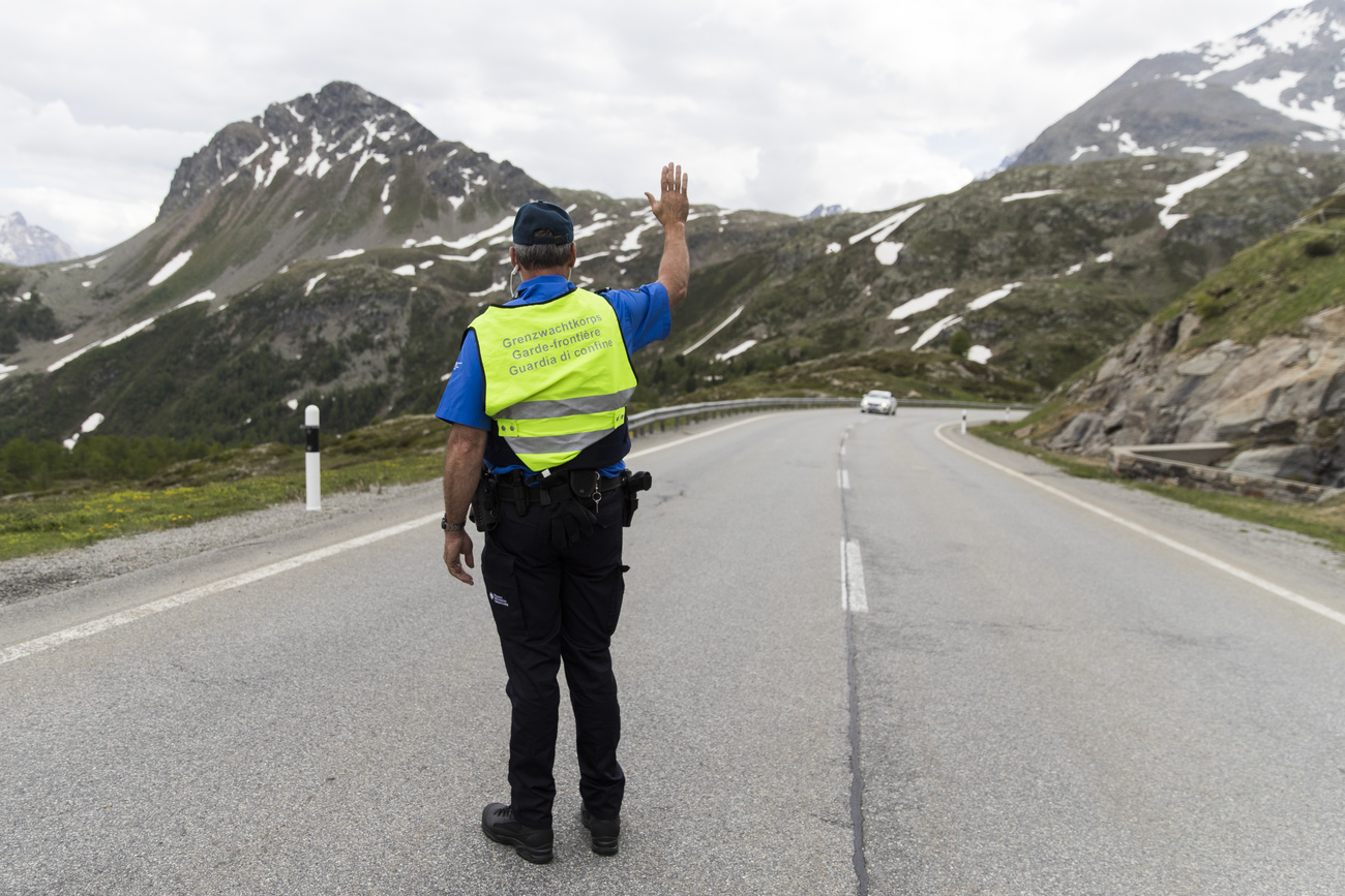 Una guardia di confine ferma un auto sul passo del Bernina.